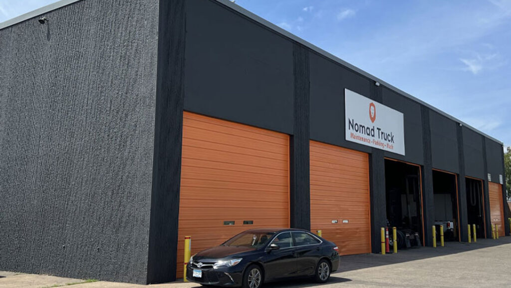 Grey warehouse with large orange garage doors - Types of Exterior Coatings